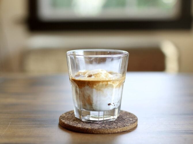 Affogato with espresso and ice cream in a glass on a cork coaster