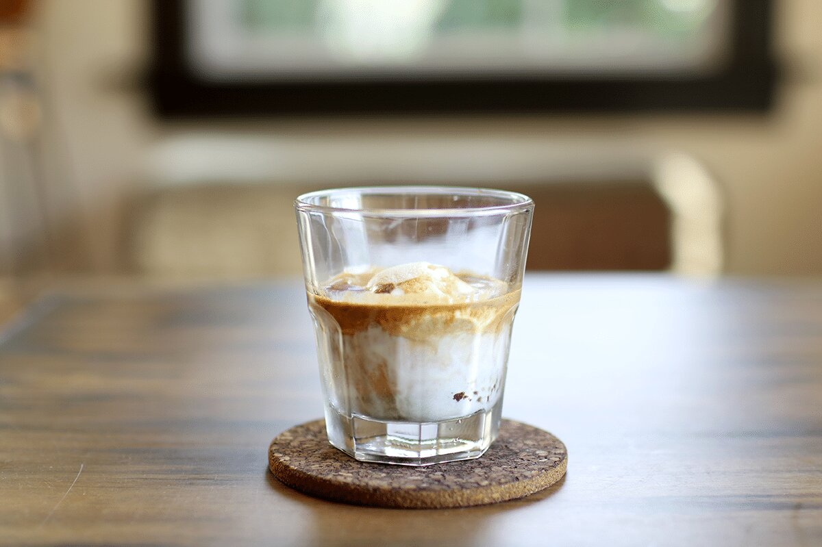Affogato with espresso and ice cream in a glass on a cork coaster