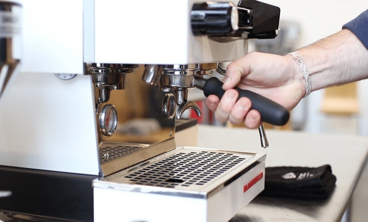 La Marzocco espresso machine portafilter being inserted into group head during shot pulling