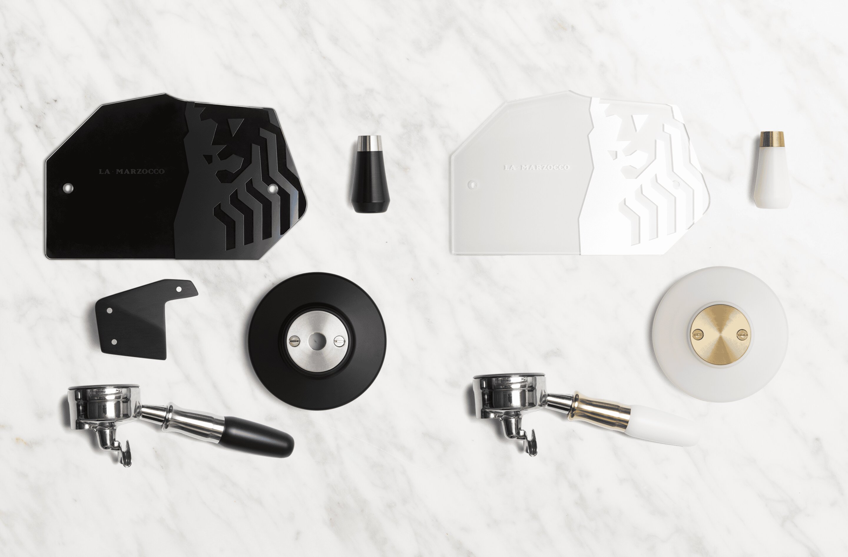La Marzocco espresso machine parts and accessories, flat lay display on marble surface