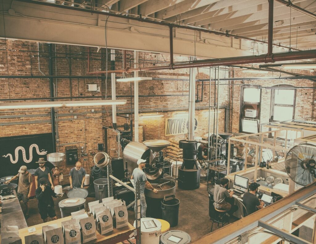 La Marzocco espresso machine manufacturing facility in Florence, with baristas operating roasting equipment and machinery