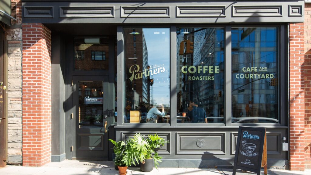 Storefront of Partners Coffee Roasters café with La Marzocco espresso machine visible through window