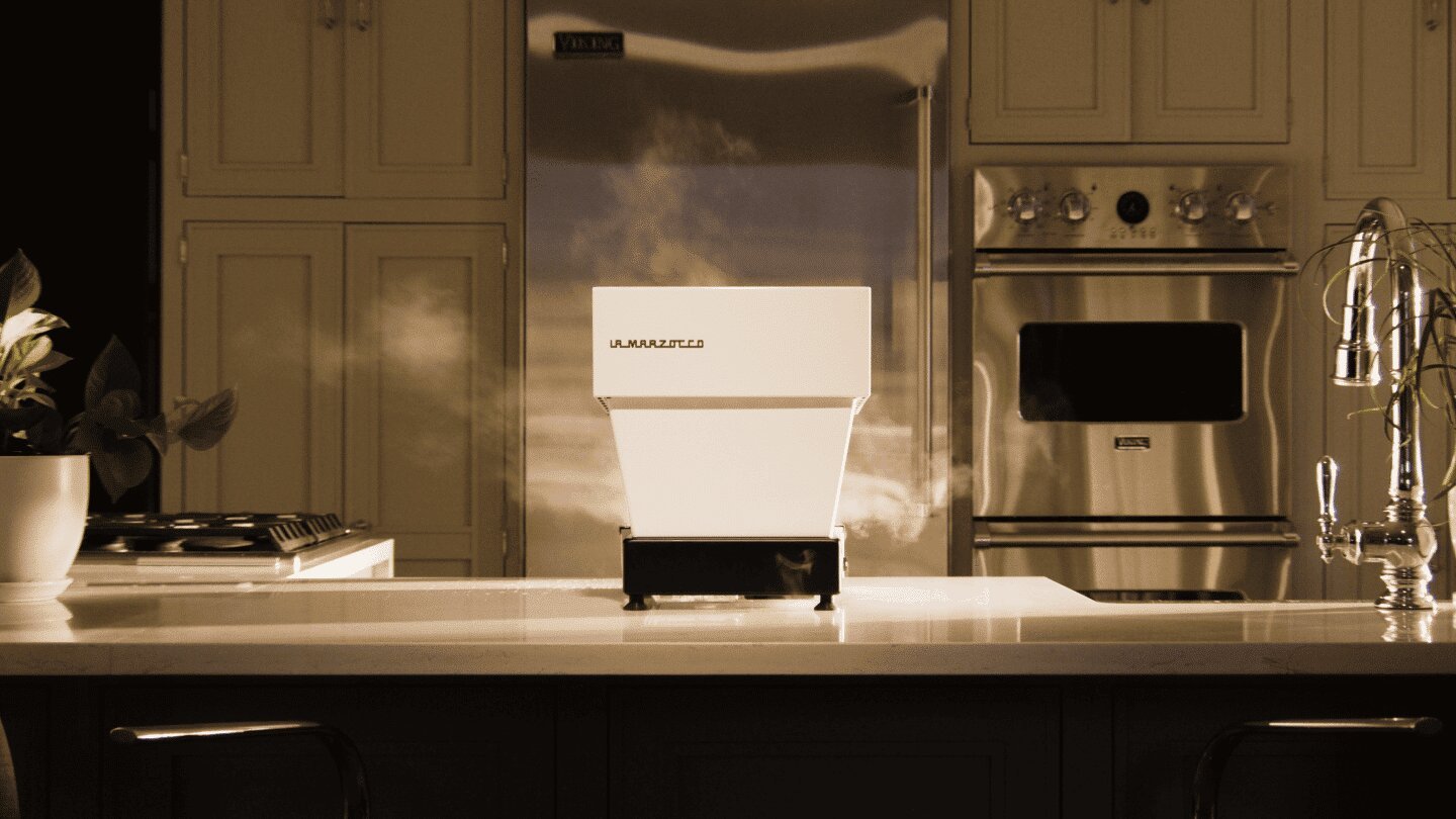 La Marzocco Linea Micra espresso machine in white with stainless steel refrigerator, modern kitchen countertop setup