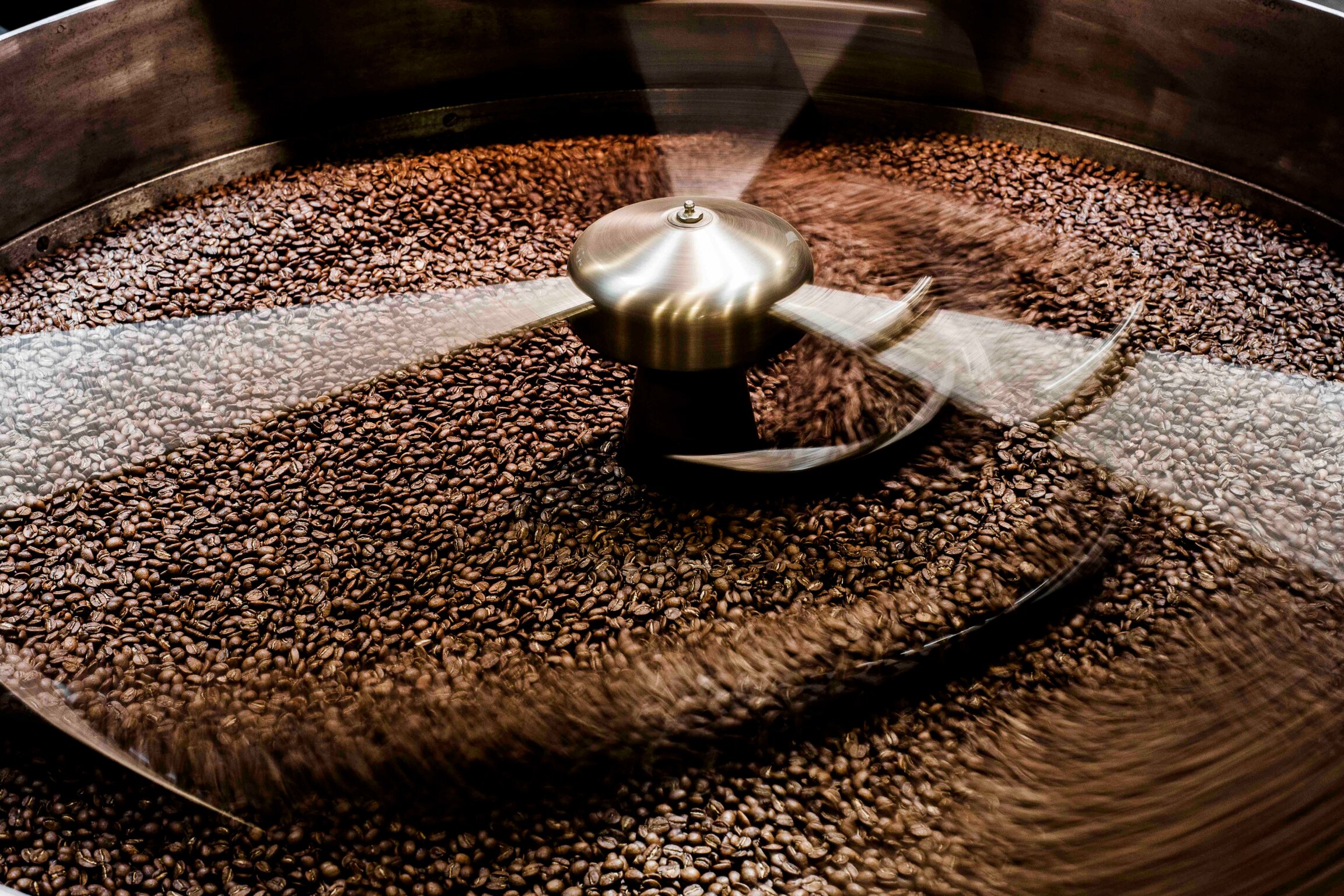 La Marzocco cooling tray with rotating drum and stirring paddles, filled with roasted coffee beans