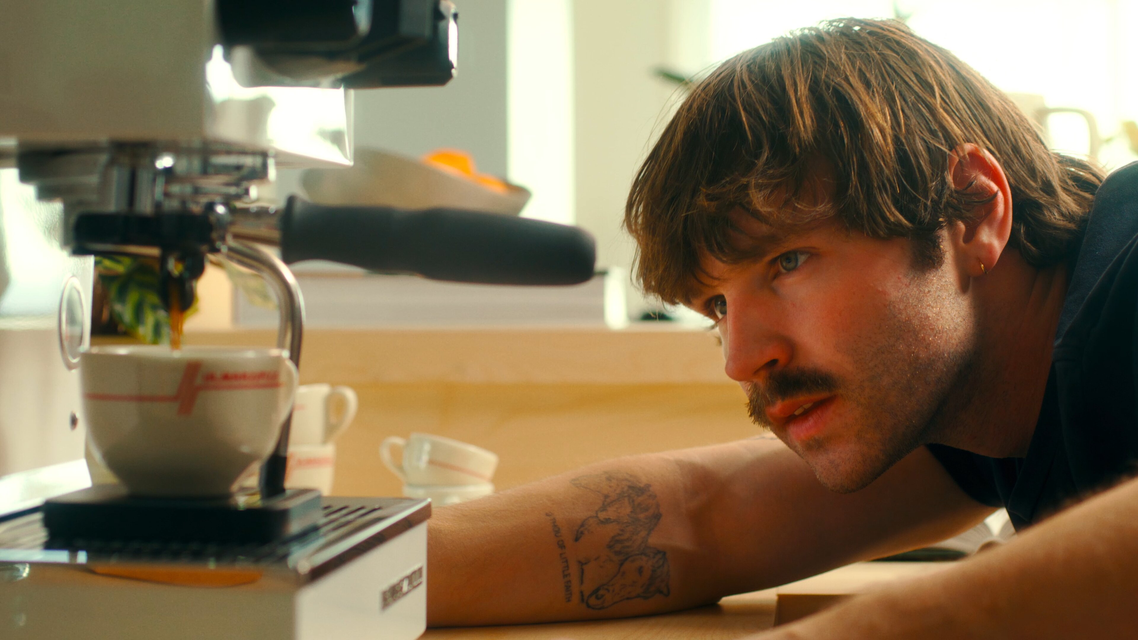 Home barista working at a La Marzocco Linea Mini espresso machine in a bright home kitchen with professional lighting setup