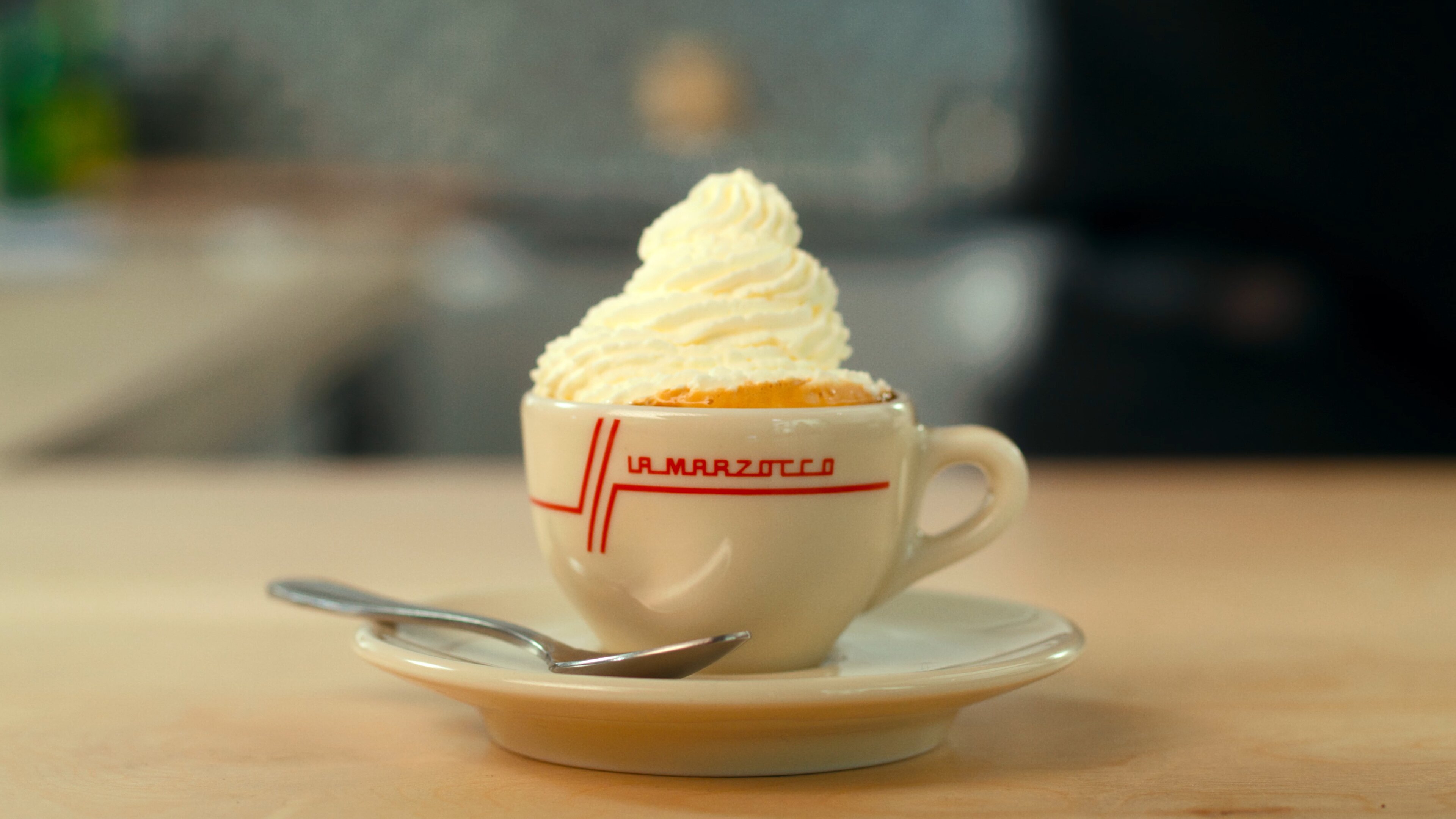 La Marzocco Linea Mini espresso machine with con panna drink in branded cup, lifestyle scene