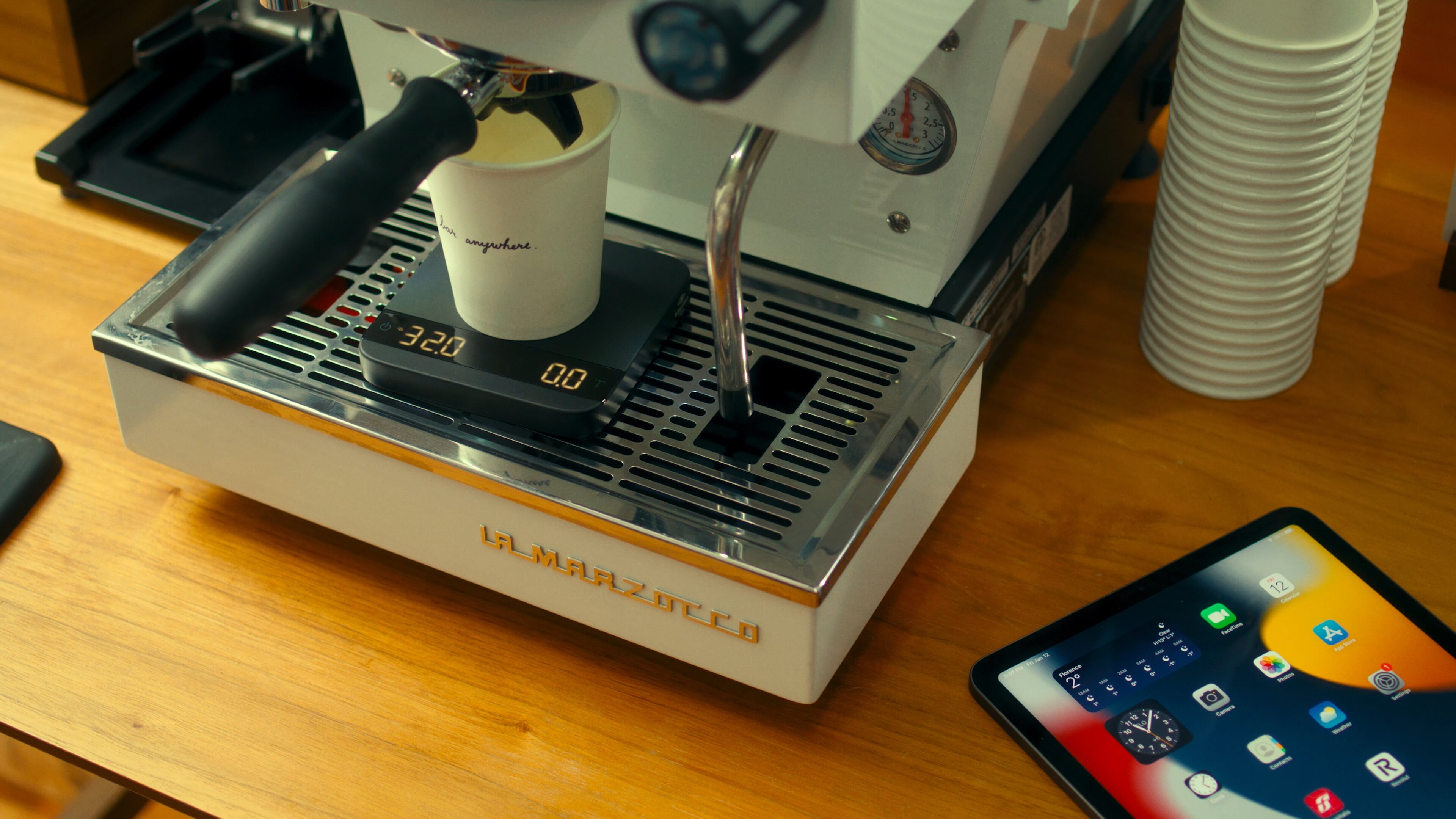La Marzocco Linea Mini espresso machine with grinder and accessories in a home barista setup on a wooden table