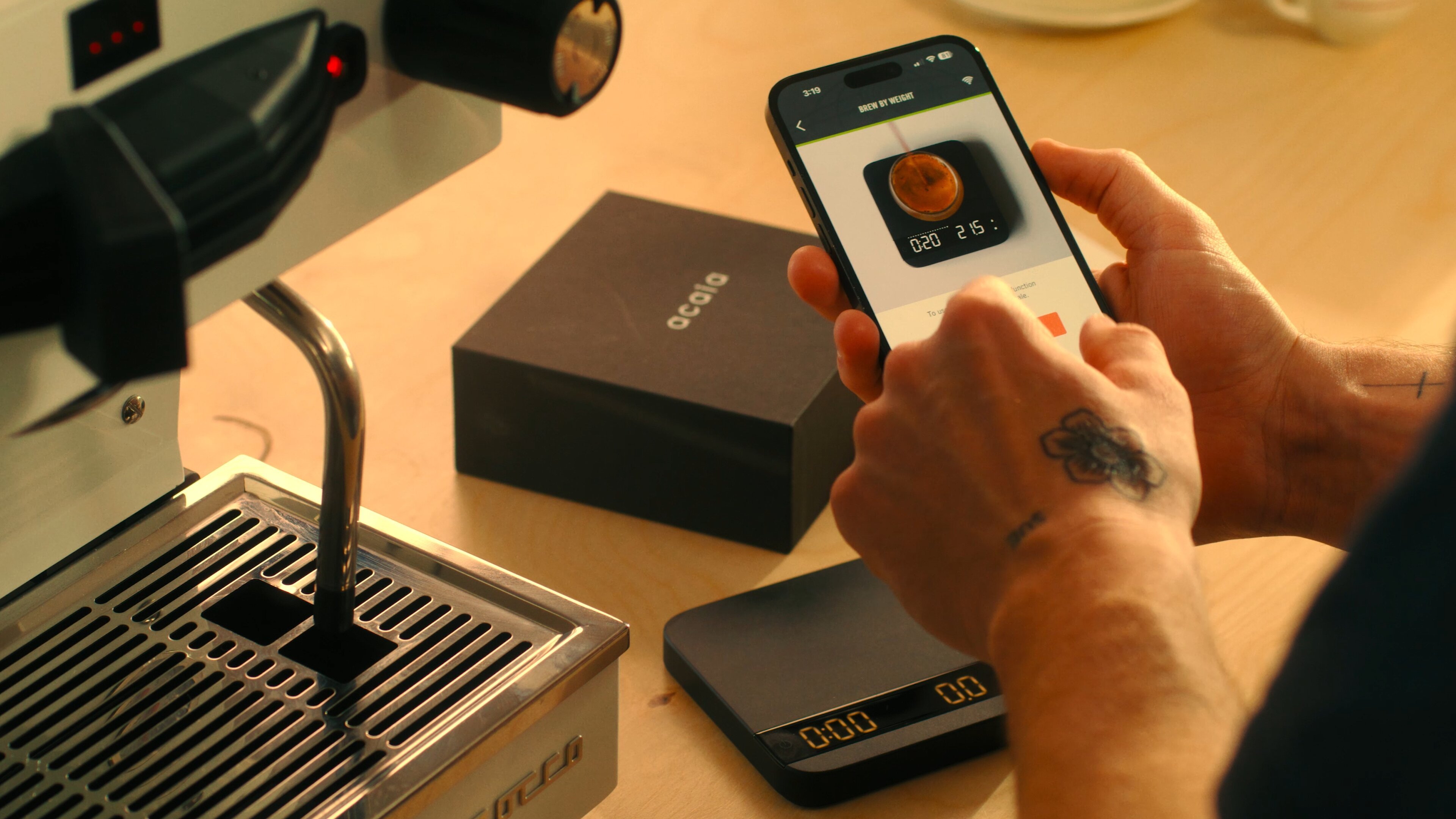 La Marzocco Linea Mini espresso machine with smartphone app displaying brew-by-weight pairing on kitchen counter