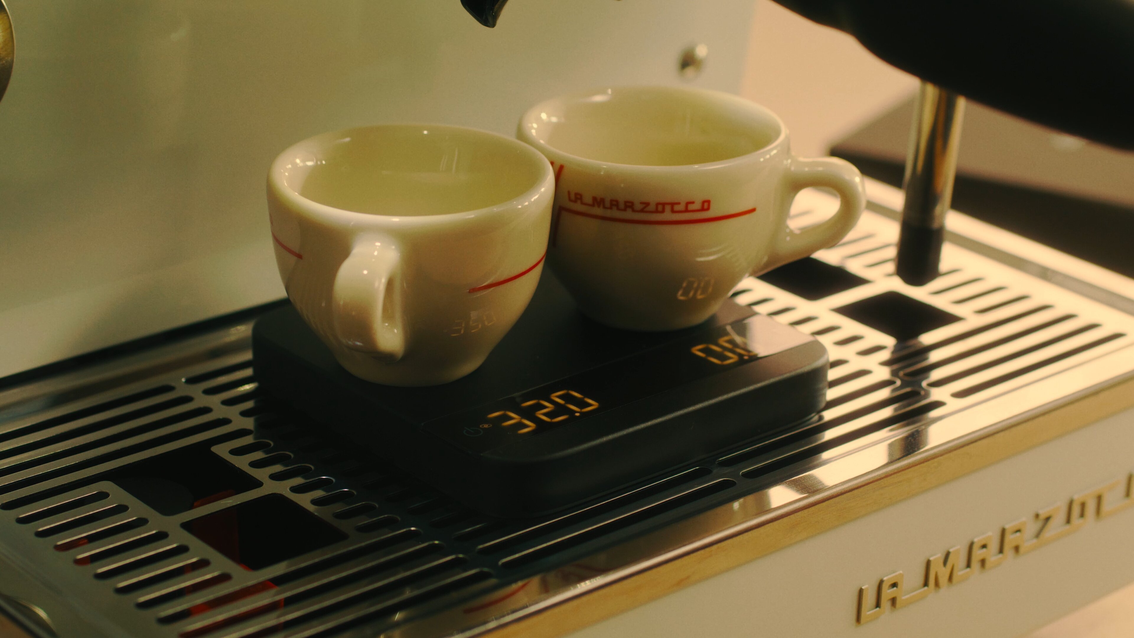 La Marzocco Linea Mini espresso machine with cups on drip tray, brew-by-weight display