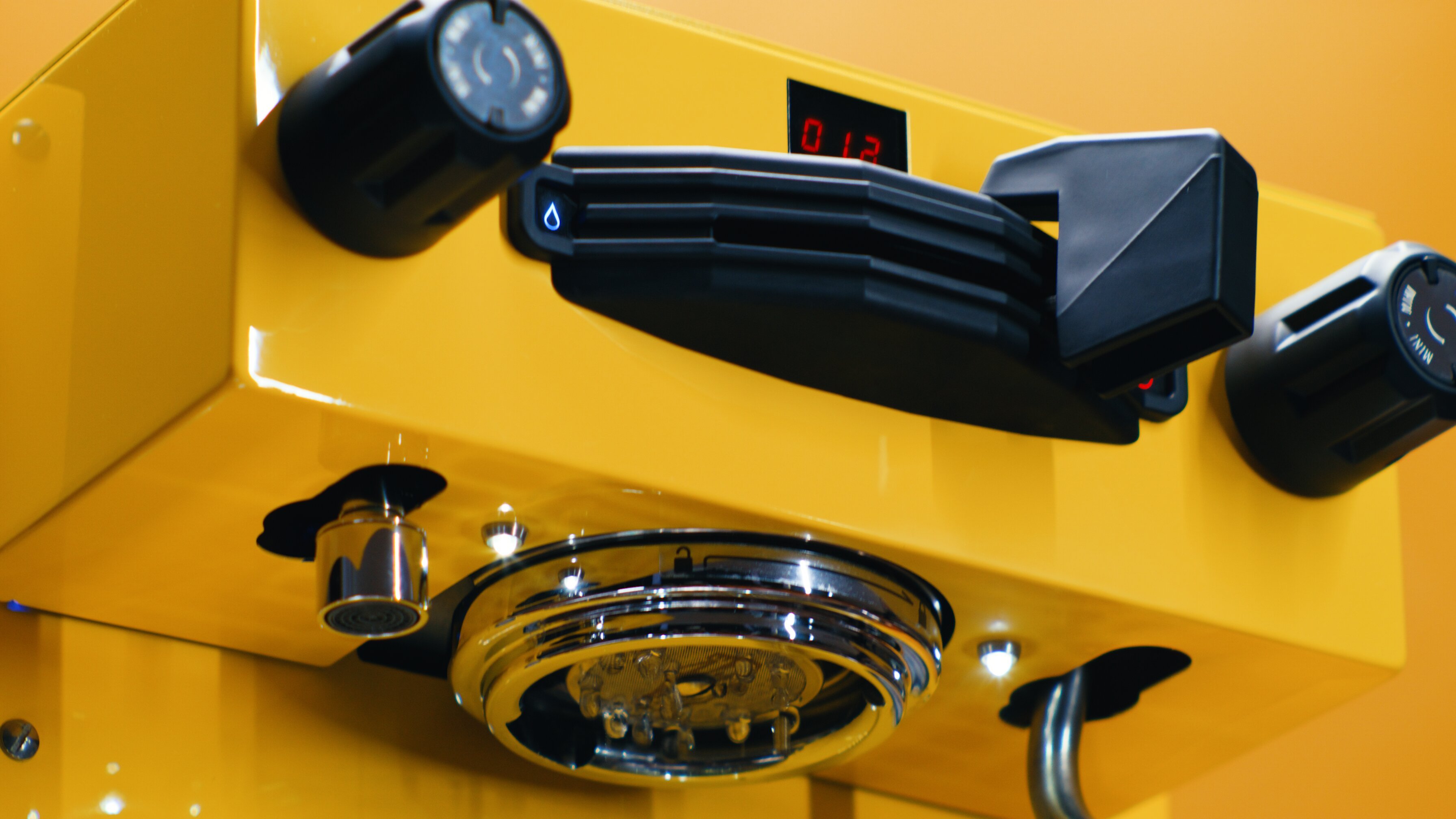 La Marzocco Linea Mini espresso machine in yellow with steam wand and control panel, close up