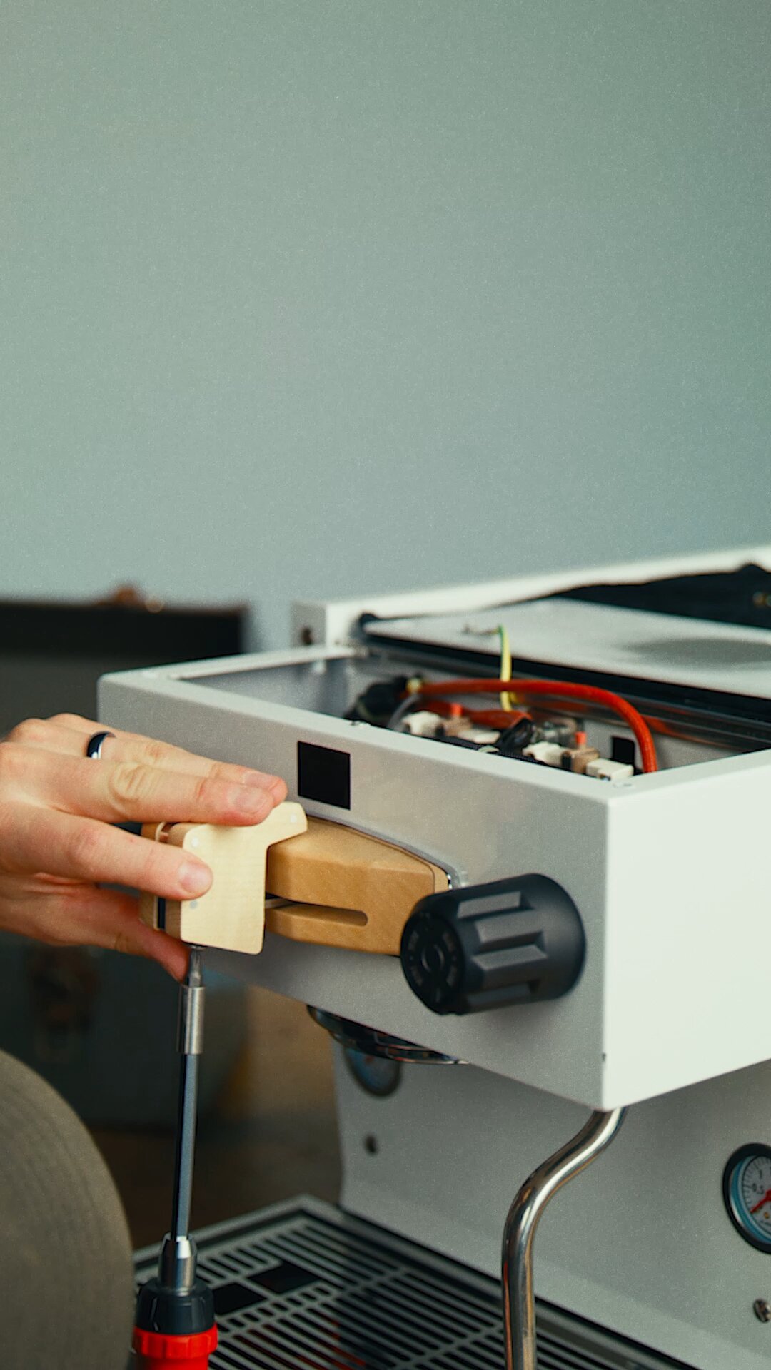 Hands adjusting the group head assembly on a La Marzocco Linea Mini espresso machine