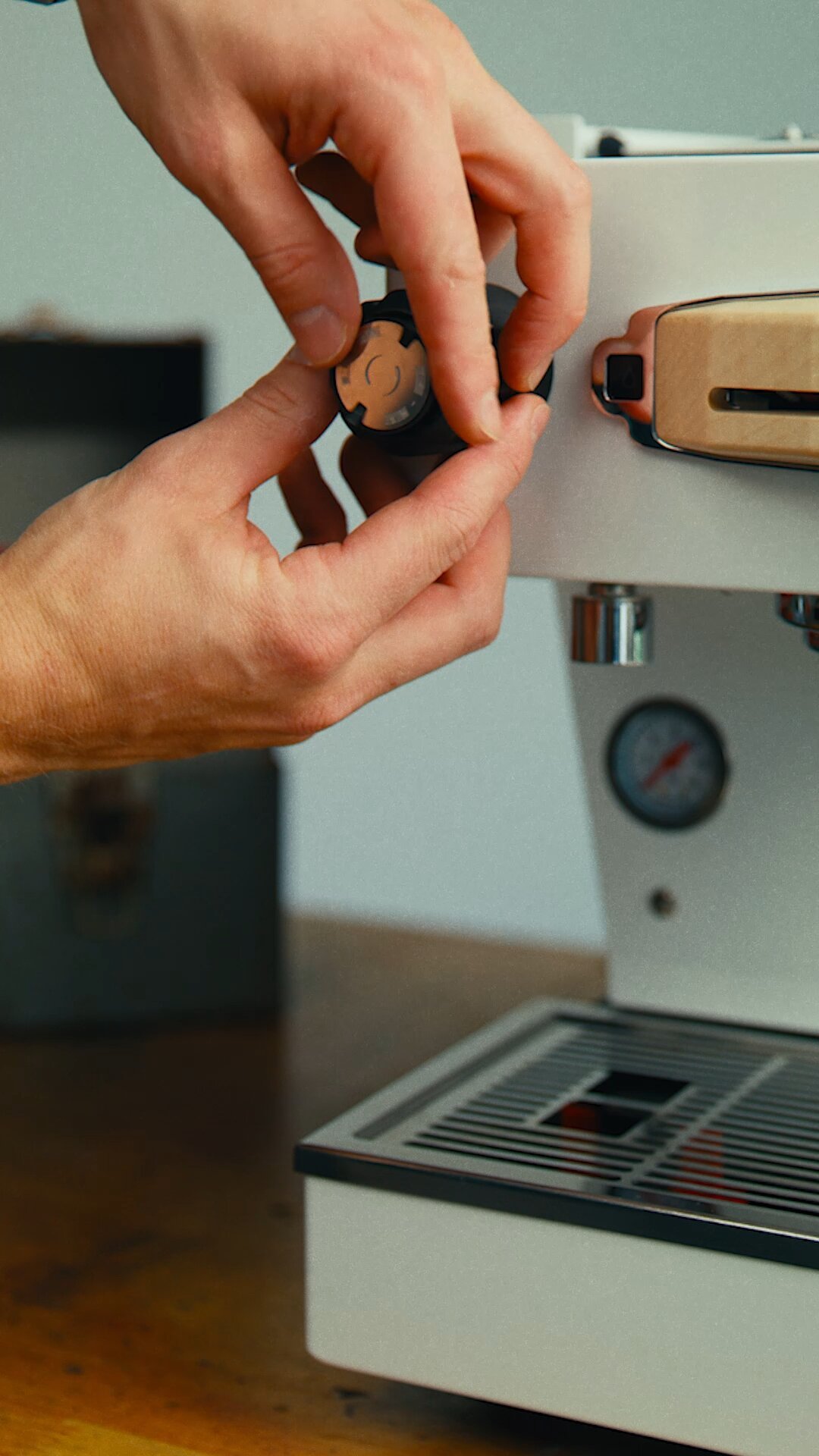 Hands adjusting a group head component on a La Marzocco Linea Mini espresso machine