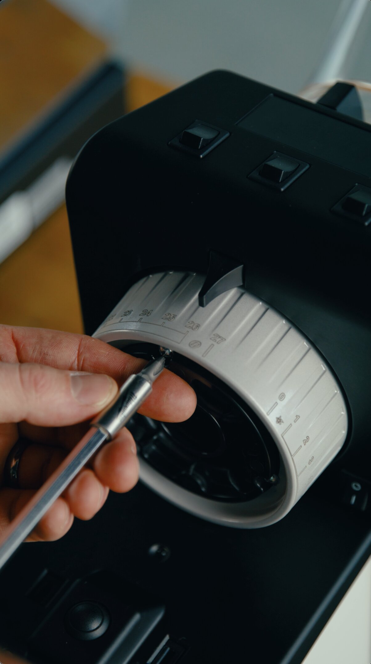 Adjusting water temperature dial on a La Marzocco espresso machine