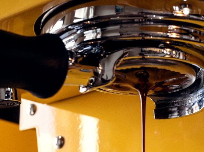 La Marzocco Linea Mini espresso machine in yellow, pouring espresso into group head basket