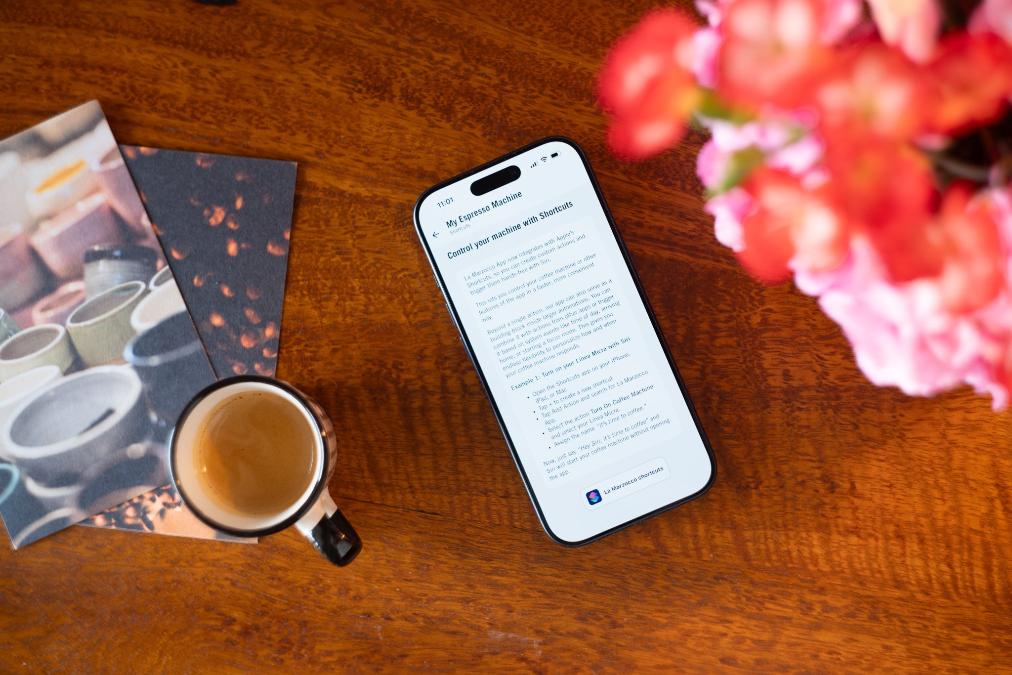 Espresso machine in home setting with coffee cup and flowers on wooden table